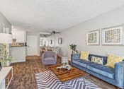 Thumbnail 6 of 32 - A living room with a blue couch and a wooden coffee table.