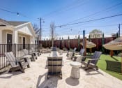 Thumbnail 50 of 56 -  Two-Bedroom Homes For Rent In Denton, TX - Carmel Villas - Firepit With Strung Outdoor Lights Surrounded By Chairs Next To Hammocks Above Turf
