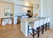 Thumbnail 1 of 36 - Stylish apartment kitchen at Gateway in Pompano Beach, showcasing a functional island, granite countertops, and high-end appliances.