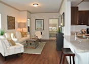 Thumbnail 14 of 33 - Living room with wood floors and couches and chairs and windows with blinds and ceiling light