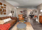 Thumbnail 22 of 34 - A living room with a brown leather couch and a grey coffee table.