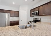 Thumbnail 6 of 26 - Harris Trail Luxury Townhomes for rent Richmond Hill, GA photo of a kitchen with granite counter tops and stainless steel appliances