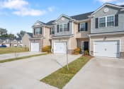 Thumbnail 25 of 28 - Omnia at Richmond Hill Townhomes in Georgia photo of exterior homes with white doors on a lengthy driveway