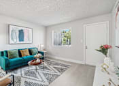 Thumbnail 5 of 34 - A living room with a green couch and a coffee table.