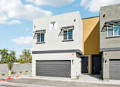 Thumbnail 1 of 20 - A modern two-story house with a garage door and a yellow section on the side.