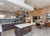 Thumbnail 16 of 34 - A modern kitchen with a large island and a dining area.