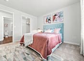Thumbnail 16 of 47 - A bedroom with a bed covered in a pink blanket.