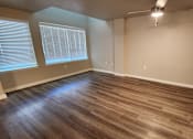 Thumbnail 4 of 16 - A room with wooden flooring and a window with blinds.