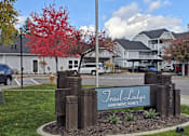 Thumbnail 17 of 17 - a sign for the trail college apartments in front of a parking lot