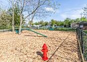 Thumbnail 37 of 48 - A red fire hydrant sits on a playground.