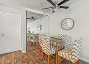 Thumbnail 7 of 32 - A dining room with a glass table and chairs with a mirror above it.