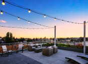 Thumbnail 34 of 50 - Studios In Greenwood, WA - The Morrow - Outdoor Rooftop Deck With Cozy Seating, Hanging Lights, Beautiful Views, And Fireplace