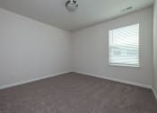 Thumbnail 17 of 25 - an empty room with a window and carpet