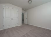 Thumbnail 16 of 25 - a bedroom with two doors and a carpeted floor