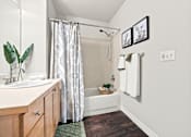 Thumbnail 21 of 47 - A bathroom with a white tub and a green rug.