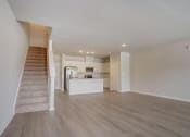 Thumbnail 14 of 19 - an empty living room with a staircase in the background
