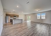 Thumbnail 10 of 21 - a spacious living room with a kitchen in the background