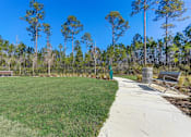 Thumbnail 54 of 56 - a park with a grassy area and trees in the background