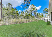 Thumbnail 55 of 56 - a yard with a house and trees in the background