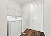 Thumbnail 23 of 47 - A small laundry room with a washer and dryer.