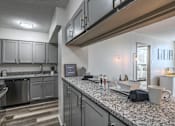 Thumbnail 5 of 20 - Kitchen at Idlewild 45 Apartments in Memphis TN featuring granite countertops and stainless steel appliances