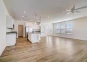 Thumbnail 15 of 20 - an empty living room and kitchen with a ceiling fan
