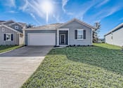 Thumbnail 20 of 21 - a home with a large lawn and a white garage door