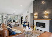 Thumbnail 19 of 34 - A living room with a brown leather couch and a white fireplace.