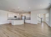 Thumbnail 3 of 20 - an open kitchen and living room with a staircase in the background