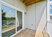 Thumbnail 20 of 48 - A balcony at Hawks Landing in Hickory NC featuring a sliding glass door and wooden flooring