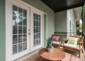 Thumbnail 12 of 25 - Pet-Friendly Apartments in Sandy Springs – Celebration at Sandy Springs - a patio with two chairs and a table