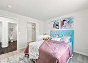 Thumbnail 19 of 47 - A bedroom with a bed, a rug, and two paintings on the wall.