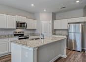 Thumbnail 3 of 21 - a kitchen with white cabinets and a granite counter top