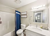 Thumbnail 15 of 46 - A white bathroom with a toilet, sink, and shower.