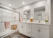 Thumbnail 24 of 29 - Houses in Lady Lake for Rent – The Groves at Lake Ella - a white bathroom with two sinks and a shower