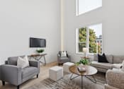 Thumbnail 14 of 65 - A living room with a grey couch, a white sofa, a coffee table, and a television.