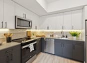 Thumbnail 1 of 65 - A modern kitchen with black cabinets and a white microwave above the stove.