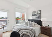 Thumbnail 2 of 65 - A bedroom with a large bed and a view of the outside.