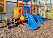 Thumbnail 3 of 36 - Outdoor playground at Gateway Luxury Apartments in Pompano Beach, featuring safe, modern play structures for children in a landscaped setting.