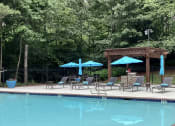 Thumbnail 15 of 27 - Place at Midway Douglasville GA sparkling swimming pool with chaise lounge chairs and umbrellas