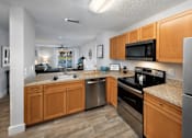 Thumbnail 5 of 28 - A kitchen with wooden cabinets and stainless steel appliances.
