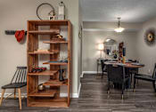 Thumbnail 24 of 34 - A room with a wooden shelf and a dining table.
