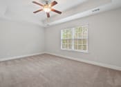 Thumbnail 15 of 26 - Harris Trail Luxury Townhomes for rent Richmond Hill, GA photo of an empty living room with a ceiling fan and a window