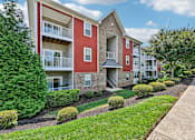 Thumbnail 24 of 48 - red and beige Hawks Landing apartment buildings in Hickory NC with green bushes in front