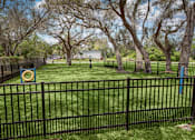 Thumbnail 10 of 34 - A black fence surrounds a green lawn with trees.