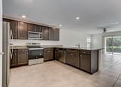 Thumbnail 46 of 56 - a kitchen with brown cabinets and a white tile floor