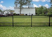 Thumbnail 11 of 34 - A black fence in front of a white building.