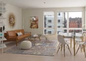 Thumbnail 22 of 36 - Apartments in Seattle, WA, with In-Unit Washer and Dryer - Origin - Open Layout Living Room with Contemporary Wood-Finish Flooring, Area Rug, Sofa, Ottoman, Armchair, Glass-Top Coffee Table, Shelf with Books and Decors, Wall Art, Decorative Floor Lamp, 4-Seater Dinette, and Large Windows with City Views