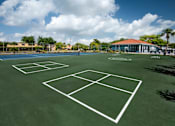 Thumbnail 4 of 28 - A tennis court with a white net and green surface.