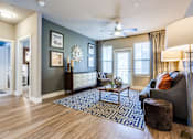 Thumbnail 6 of 16 - Bright spacious living room with large windows and wood-style floors at 33hundred Apartments Austin TX 78728
